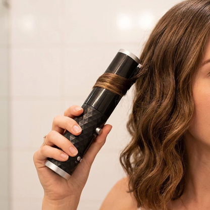Woman holding CordlessCurl curling wand near her wavy hair