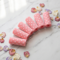 DreamWave pink polka dot sponge hair rollers flat-lay on white marble vanity with rose petals